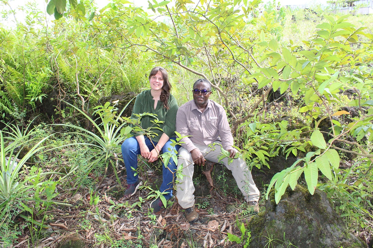 Two people sitting on a log in the forest